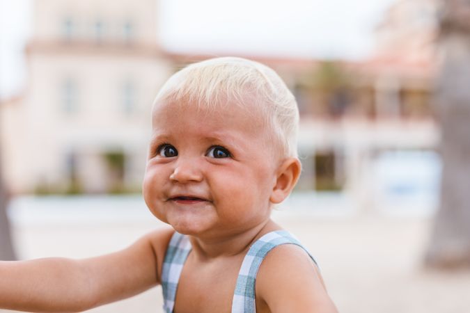 Portrait of a blonde baby smiling on the beach