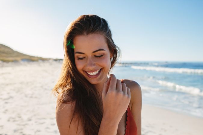 Smiling female model posing on the seashore