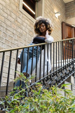 Black woman standing near railing of stairway