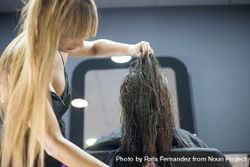 Hair stylist playing with brunette wet hair before cut 43YmO0
