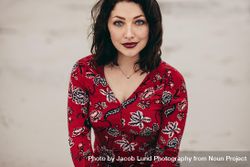 Beautiful female model posing confidently in red dress outdoors 41koj0