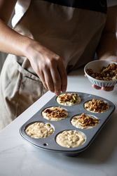Faceless person cooking muffins with walnuts
