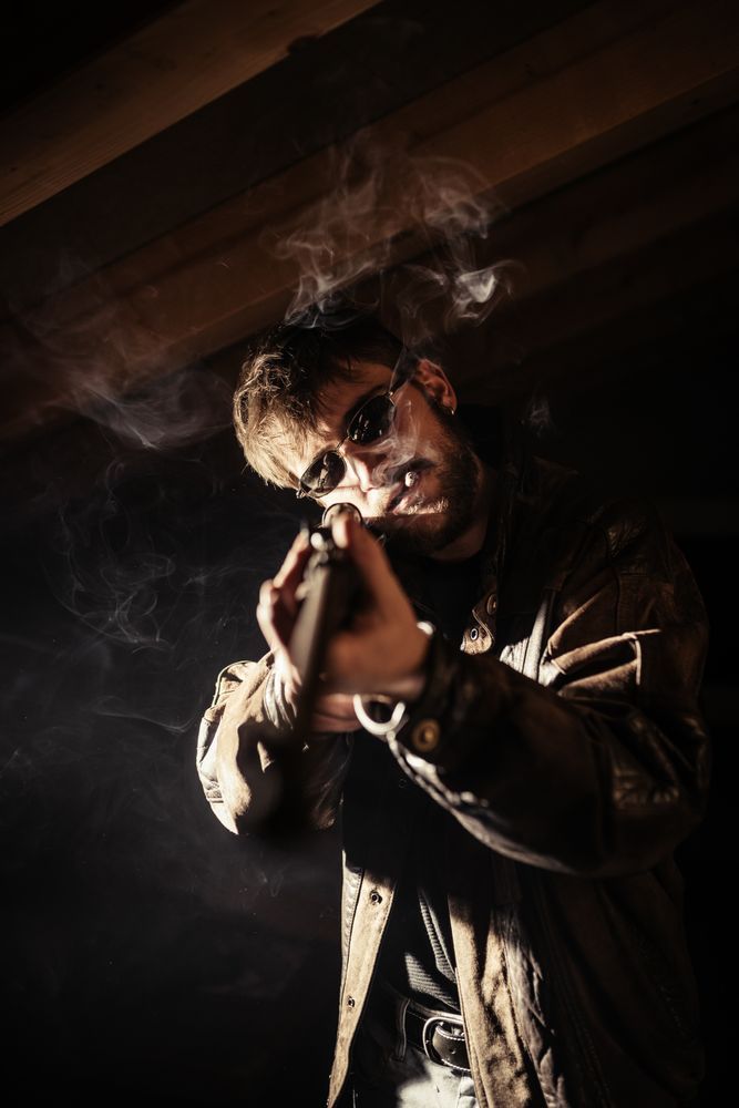 Man with shotgun and cigarette
