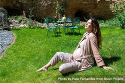 Calm pregnant woman enjoying the sun while sitting on the grass 5pm3w4