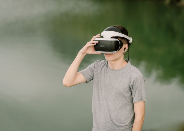 Young teenager with virtual reality glasses outdoors