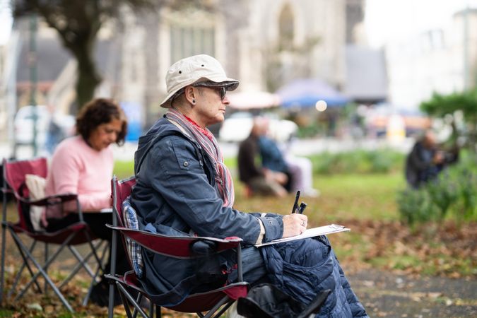 Side view of man drawing in park