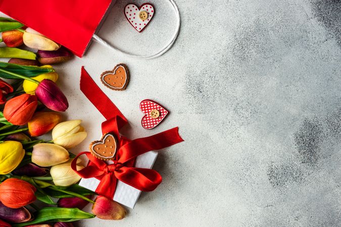 Tulips and checkered heart ornaments with present on grey counter