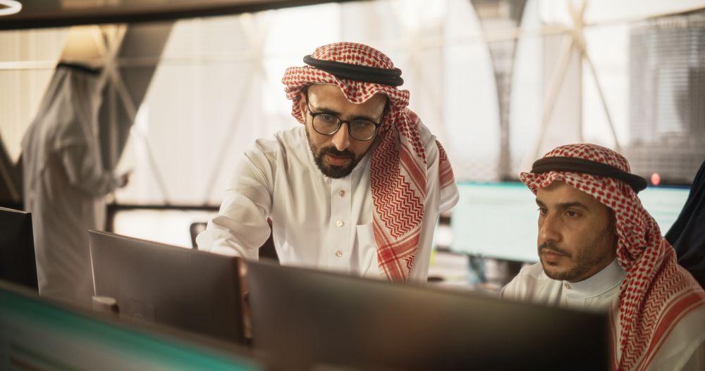 Arab Graphic Designer Working on Computer, Discussing Project with Team Leader.