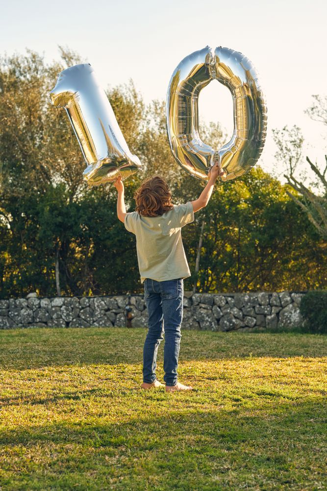 Anonymous boy with number ten made out of balloons