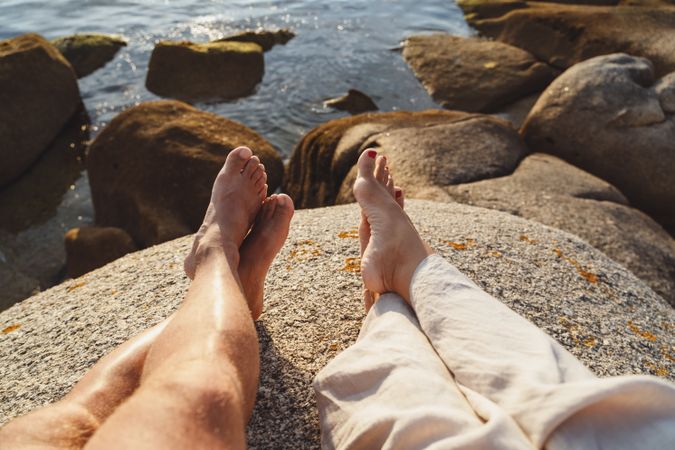 Couple chilling on stone at coast