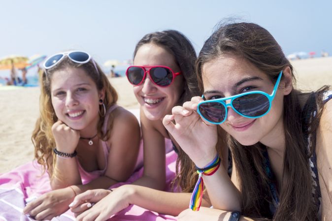 Smiling teenage girls at the beach and looking at camera