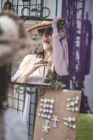 Female trying on hat looking at mirror