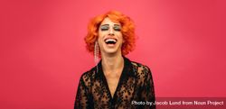 Portrait of drag queen laughing on red background 4AJoRb