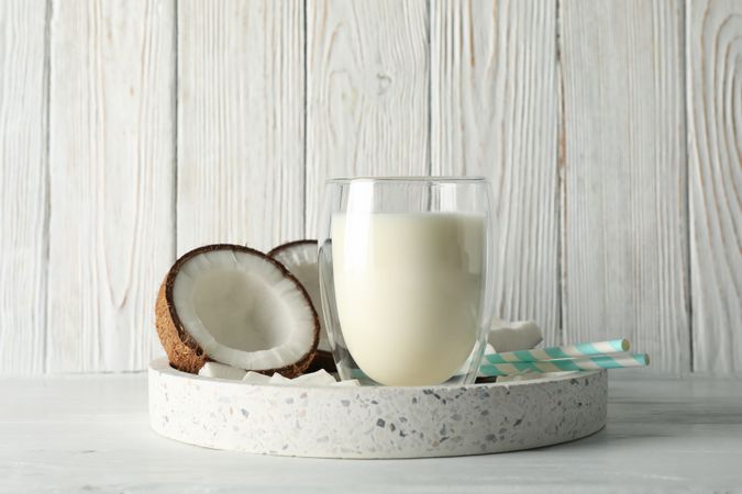 Tray with coconut and milk on wooden background. Tropical fruit