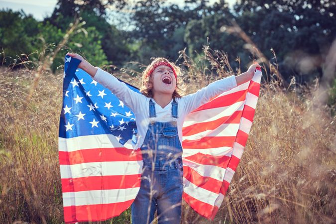 Excited child with USA flag in nature