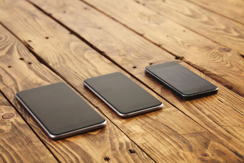 Three different sized phones on table