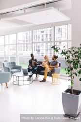 Coworkers having a discussion in a bright modern office R5R2B5