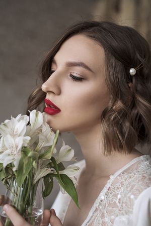 woman with red lips holding white flowers and dreaming