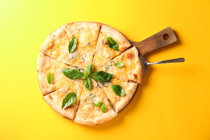 Cheese pizza on yellow background, copy space