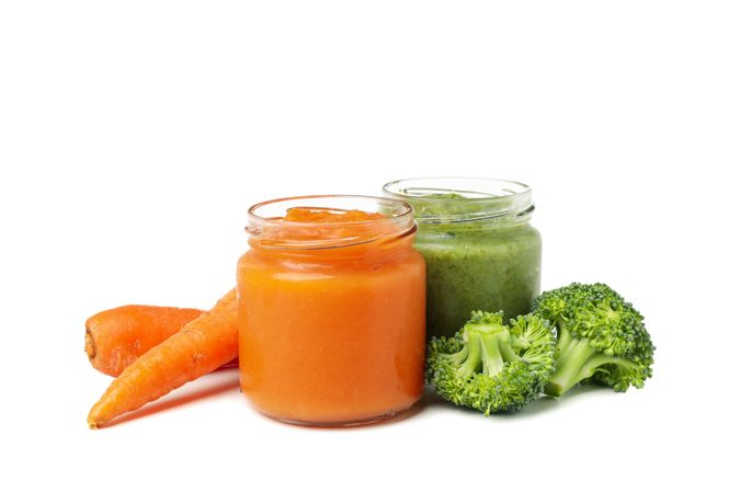 Glass jars with healthy baby food isolated on plain background