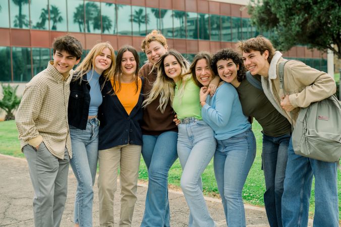 Group of cheerful diverse friends standing on road