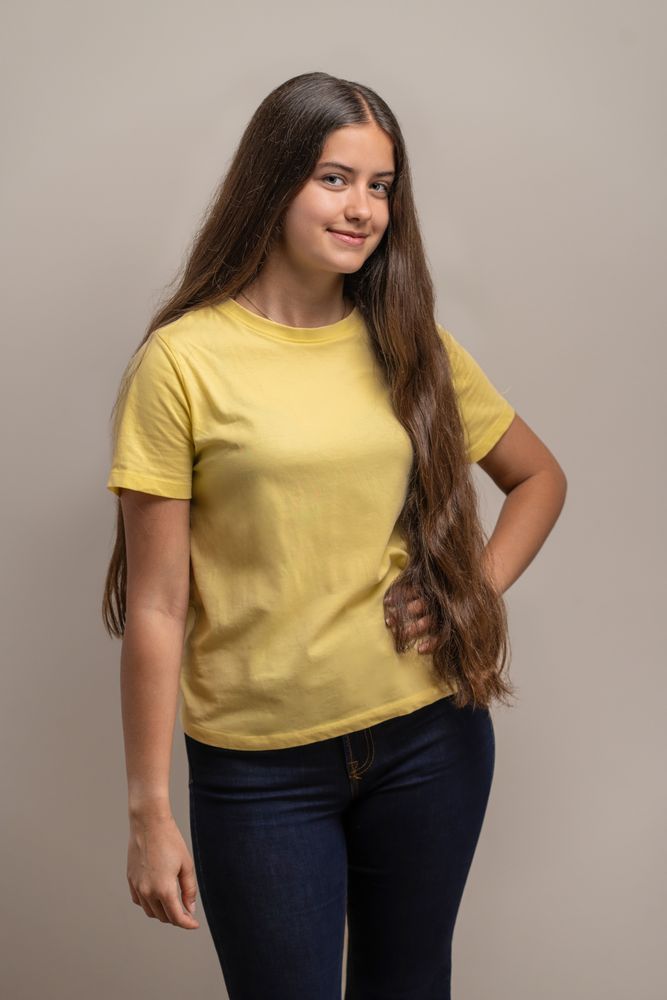 Confident young woman with hand on hip posing for a studio portrait.