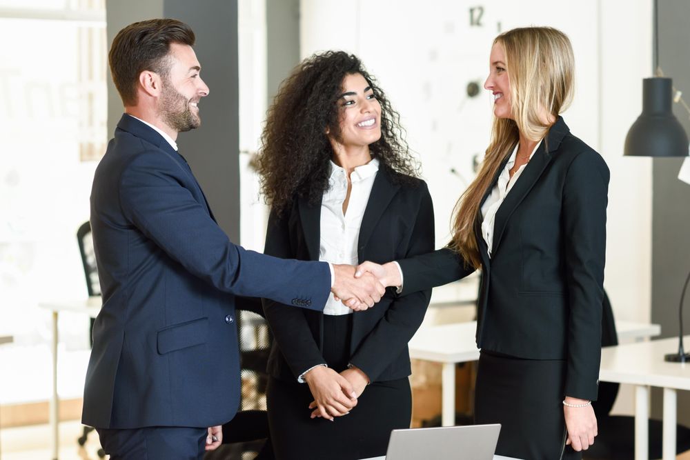 Co-workers shaking hands after a successful meeting in office