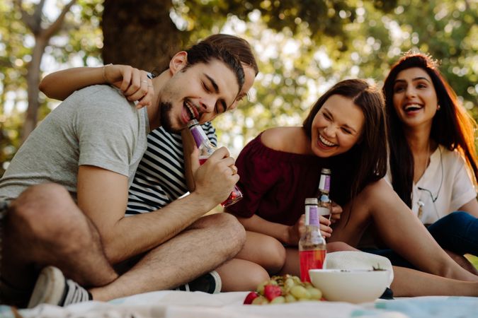 Group of friends enjoying with drinks at picnic