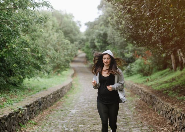 Positive woman running in park