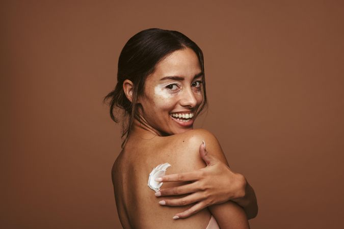 Young happy woman taking care of her skin