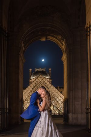 Just married couple in wedding clothing cuddling under moonlight