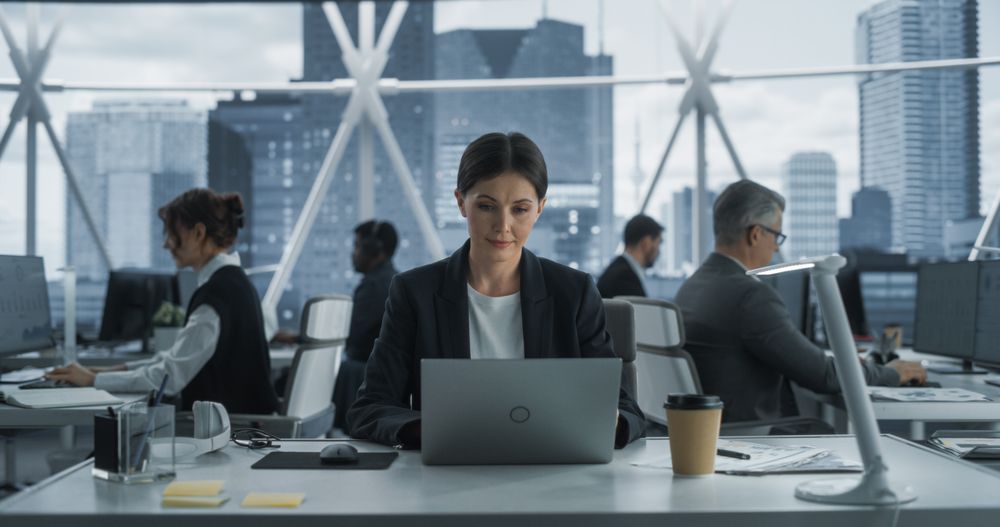 Female Project Manager working On Laptop In Skyscraper Office In Downtown.