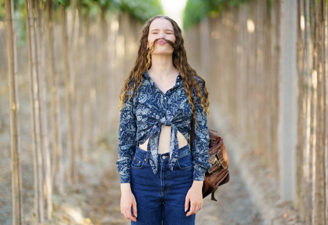 A Joyful Young Woman Embracing Nature with Her Unique Fashion Style and Playful Attitude
