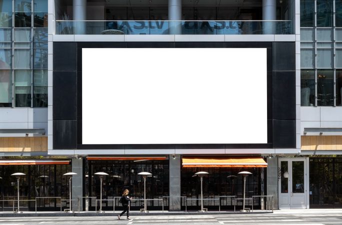 Large LED billboard mockup  on commercial building with restaurant underneath