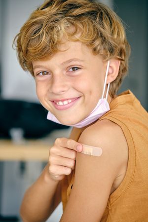 Cheerful boy with patch and medical mask