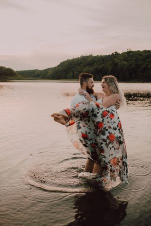 Loving couple standing ankle deep in water on beach