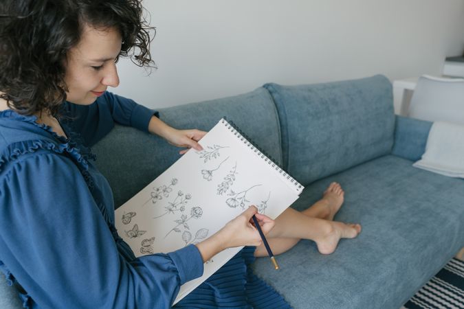 Woman artist drawing at sofa