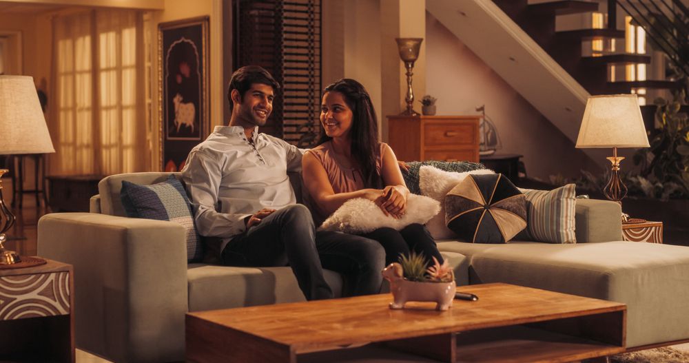 Movie Night: Young Couple Relaxing on the Couch, watching Exciting Movie on TV.