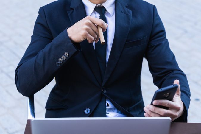 Businessman smoking cigar in street cafe