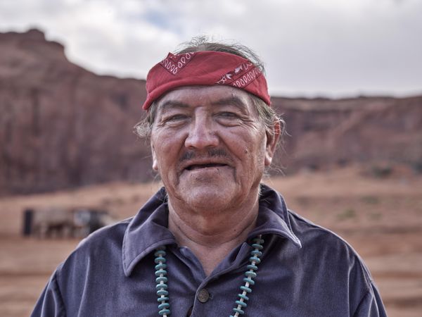 Older Navajo man wearing red bandana with blurred background