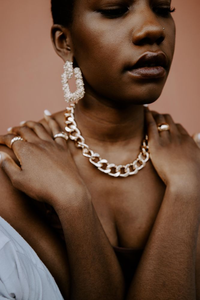 Portrait of woman wearing gold necklace and gold ring and gold earring
