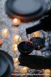 Overview of wine being poured at romantic holiday table 4OdoLb