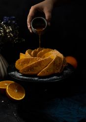 Hand pouring drizzle on bundt cake