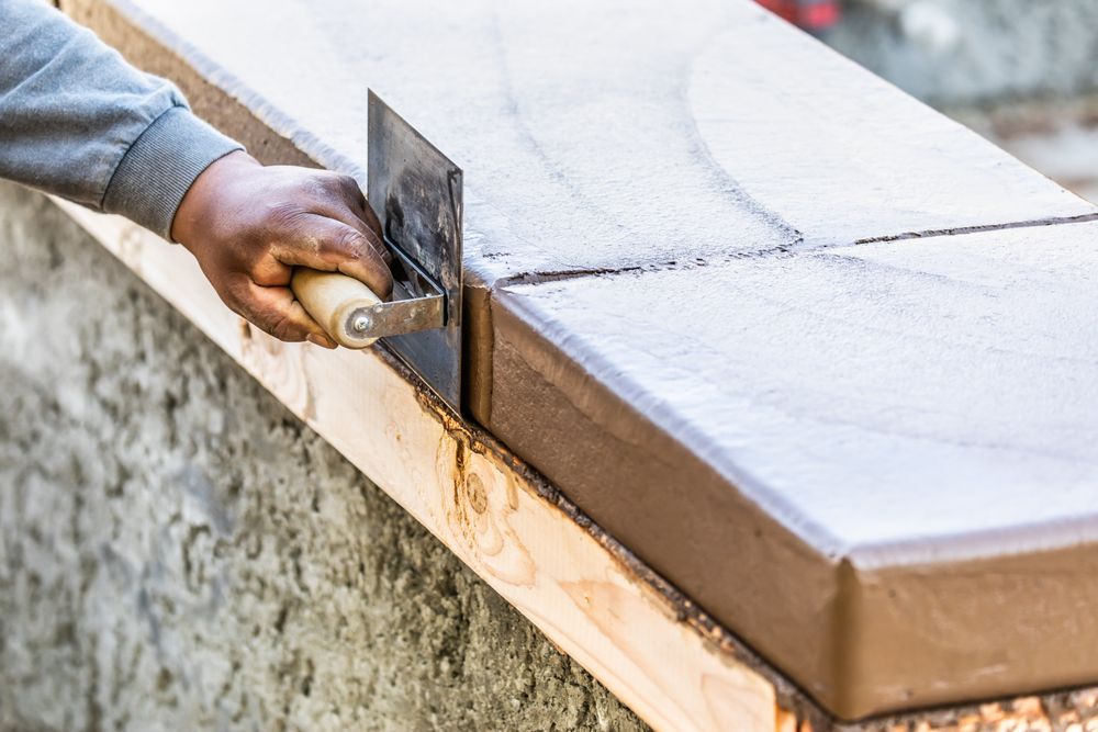 Construction Worker Using Stainless Steel Edger On Wet Cement Forming Coping Around New Pool