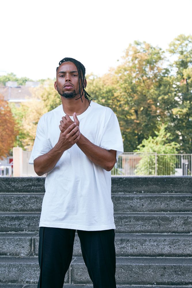 Trendy Black man posing near modern arch