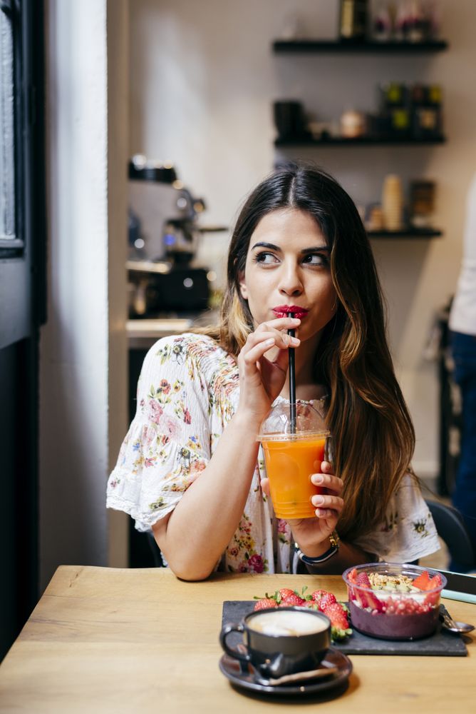 Woman enjoying smoothie with lunch