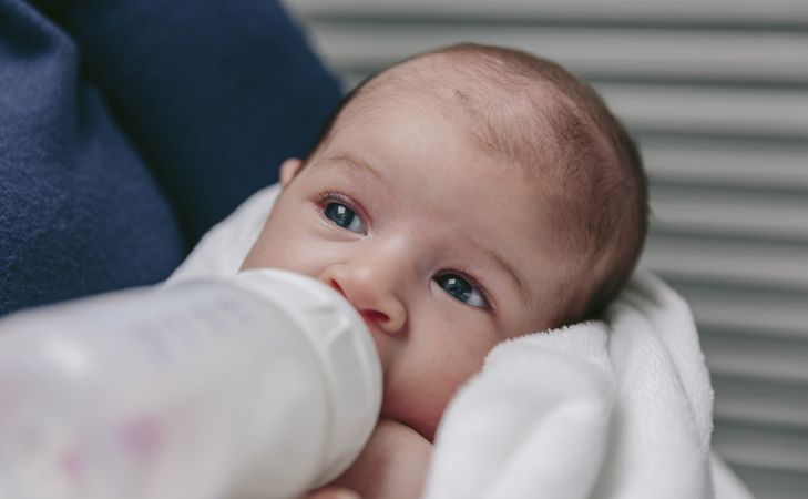 Baby taking feeding bottle