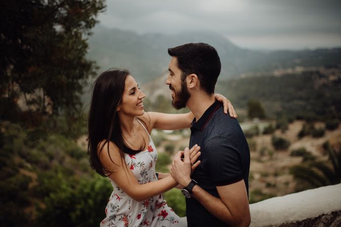 Loving couple embracing while standing against rural valley