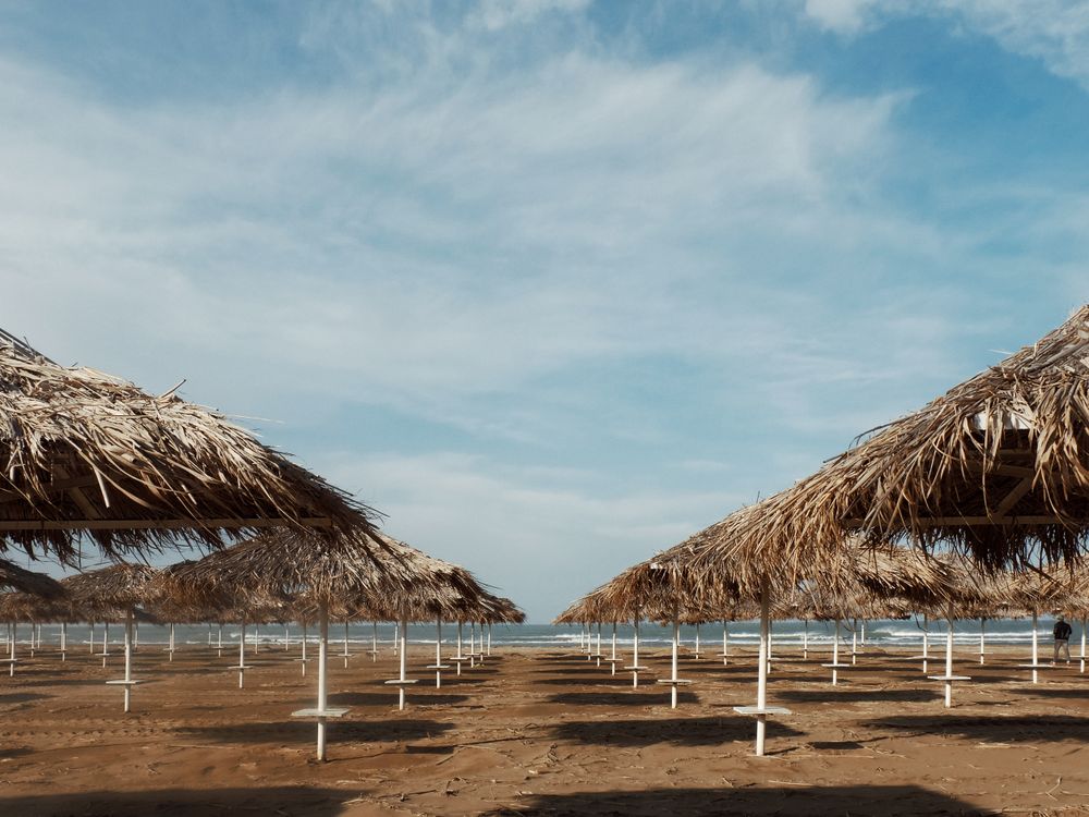 Straw umbrellas on an empty beach