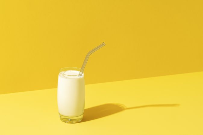 Glass of milk minimalist on yellow background